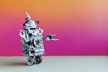 Two wheels robot repairman with hand wrench and pliers. Fixing maintenance concept. Creative design mechanic two weels robotic character. Pink orange wall, gray floor background. Copy space.