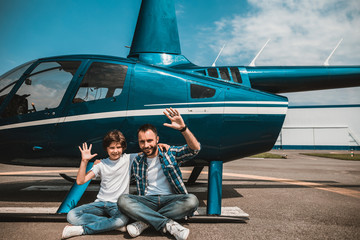 Full length portrait of smiling kid and positive unshaven man gesticulating hands while resting...