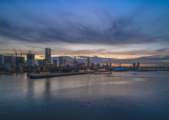 Fototapeta premium Panorama from Osanbashi Pier port of the Landmark Tower, Big Wheel, the Pacifico Yokohama Hall and the Red Brick Warehouse are illuminated by the sunset sky in the Minato Mirai district of Yokohama.