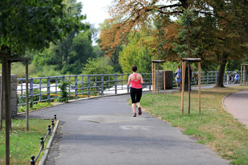 Dziewczyna biega aleją wzdłuż rzeki Odry we Wrocławiu.