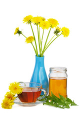 Cup of herbal tea, jar of honey and dandelion flowers