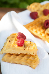 Sweet heart shaped waffles with raspberries for dessert outdoor picnic in the garden.