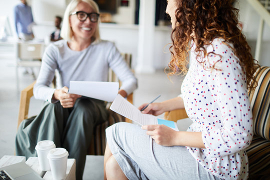 Young Businesswoman Sitting On Chair With Her Resume During Job Interview