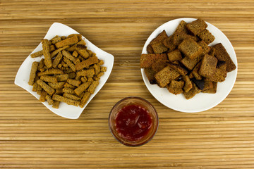 Black snack on a plate. Wooden table. Salty food for beer