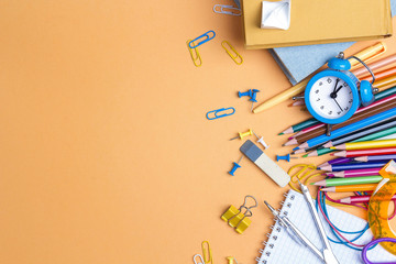 Back to school concept with school supplies and copy space on yellow background.