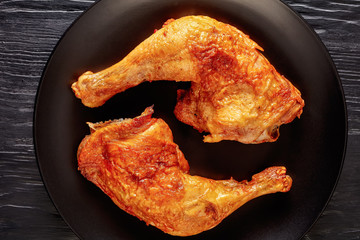 fried chicken legs on a black plate