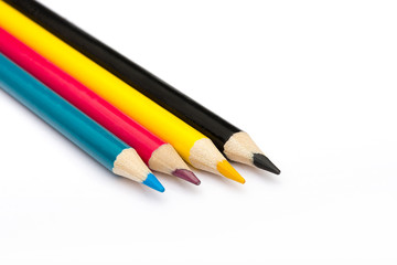 Four colored pencils. The colors cyan, magenta, yellow and black. The concept of polygraphy.