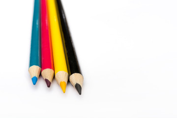 Four colored pencils. The colors cyan, magenta, yellow and black. The concept of polygraphy.