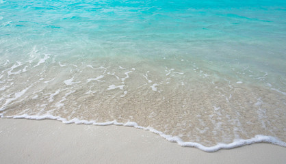 Fototapeta na wymiar Waves breaking on a sandy beach in the Maldives Islands