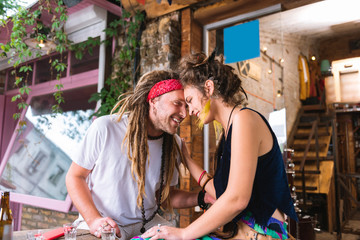 Hugging girlfriend. Hippie man with long hair feeling lovely and happy while hugging his beautiful...