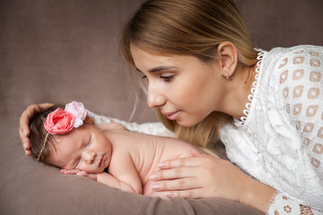 Obraz na płótnie Canvas Portrait of mother hugging her newborn baby girl