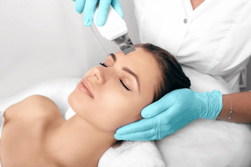 Beautiful woman receiving ultrasound cavitation facial peeling. Cosmetology and facial skin care....
