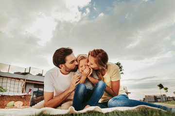 We love you. Positive unshaven father and satisfied mother expressing their love for happy daughter...