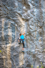 The climber is training to climb the rock.