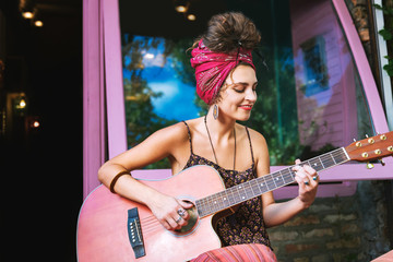Favorite melody. Happy musician wearing floral shirt smiling broadly while playing her favorite...