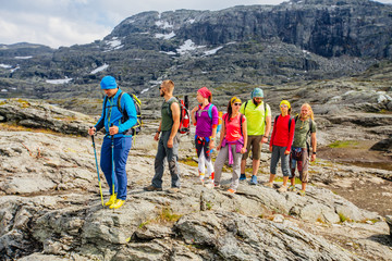 Group of seven mountaineer hiker walking on rocky terrain seven members team sport clothing Climbing gear up mountain peaks in Norway trip