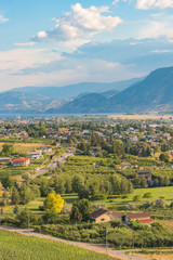 City of Penticton view with orchards and vineyards and Skaha Lake and mountains in distance in summer