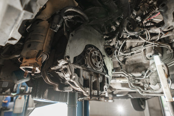 Change and repair clutch, drive axle. working underneath a lifted car. Professional mechanic work...