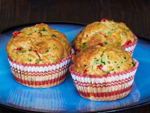 A plate with savory muffins with cheddar, spinach and red peppers