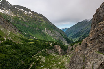 Obraz premium Scenic view of beautiful landscape in Swiss Alps. Fresh green meadows and snow-capped mountain tops in the background in springtime, Switzerland.