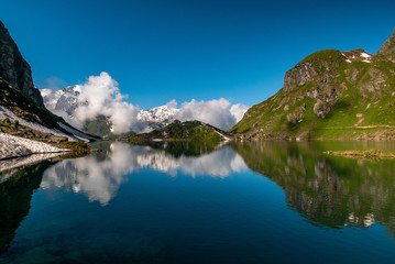 Obraz premium Swiss alps water reflection in Lac de Louvie - mountain lake above Val de Bagnes valley, Switzerland.