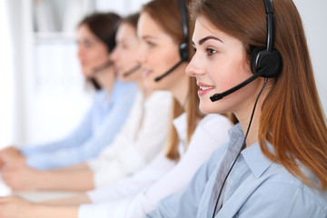 Call center. Beautiful cheerful smiling operator consulting clients with headset. Business concept...