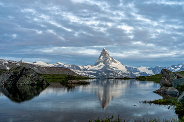 Obraz premium Very early morning shot of the Matterhorn (Monte Cervino, Mont Cervin) pyramid and Stellisee lake. Blue hour before sunrise. Great june outdoor scene in Swiss Alps, Zermatt, Switzerland, Europe.