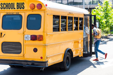 Fototapeta na wymiar Students walking into school bus at parking