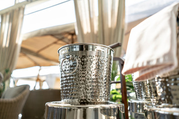 Metal buckets with an ice for cooling drinks. Service area the waiter in restaurant. silver shiny container. Catering set-up ready for the event to begin.