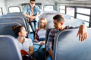 group of teen scholars riding school bus and spending time together