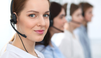 Call center. Beautiful cheerful smiling operator consulting clients with headset. Business concept of customer service