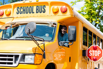 handsome senior school bus driver looking at camera through window