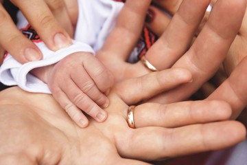 Obraz na płótnie Canvas hands of parents and their baby. parents are holding their baby's hand