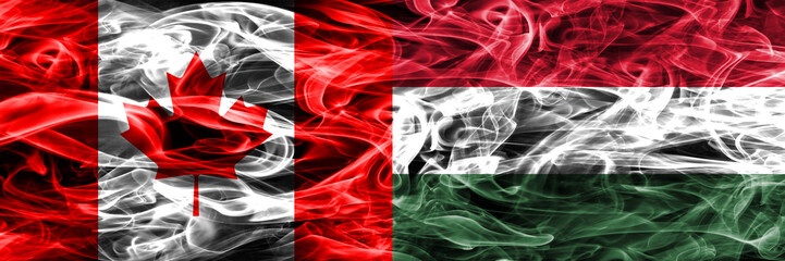 Obraz premium Canada vs Hungary smoke flags placed side by side. Canadian and Hungary flag together