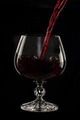 Fototapeta na wymiar Glass still life image A glass of red wine in a glass on a black background