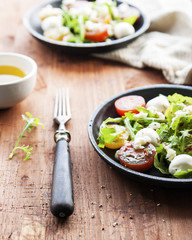 Fresh summer salad with mixed colour cherry tomatoes, lettuce, arugula and mozzarella cheese