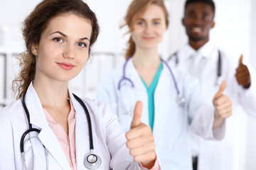 Fototapeta premium Medical team of confident doctors showing Ok sign with thumbs up. Medicine and health care, insurance concept