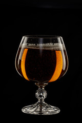 A glass of cognac on a black background close-up