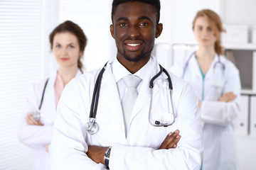Happy african american male doctor  with medical staff at the hospital. Medicine concept