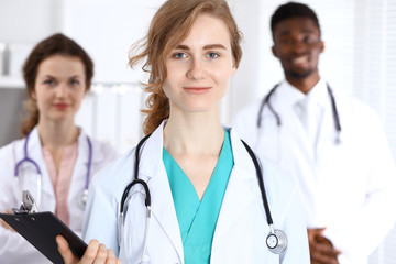 Fototapeta premium Happy doctor woman with medical staff at the hospital