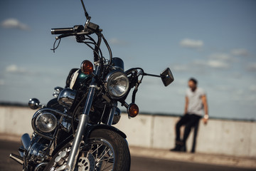 Fototapeta na wymiar selective focus of classical chopper motorbike and man on background