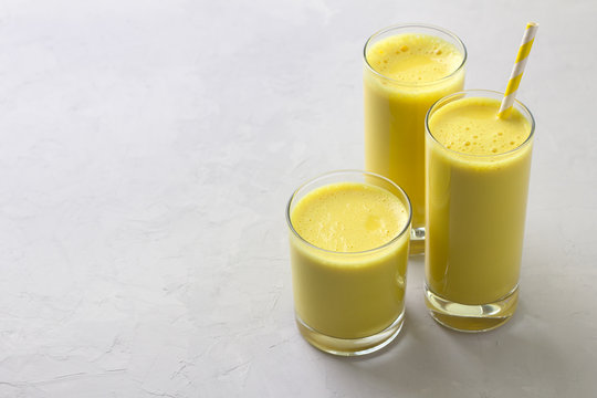 Golden milk with turmeric in a glass on a gray stone background. healthy natural energy drink. selective focus. free space