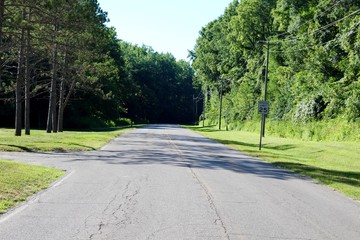 Fototapeta na wymiar The empty park road in the park on a sunny summer day.