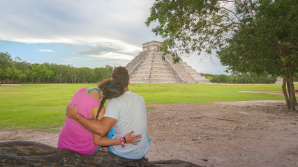 Young couple enjoying the amazing Kukulkan pyramid in Chichen Itza, Mexico