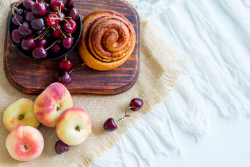 Homemade cinnamon buns in glaze on a dark plate with berries