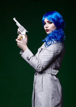 Portrait of young woman in comic  pop art make-up style.  Female with gun in hand