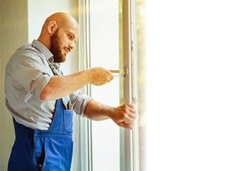 Young repairman fixing window frame in room