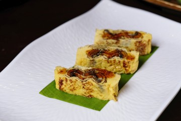 Japanese egg rolls with Grilled Eel (Unagi) on white plate