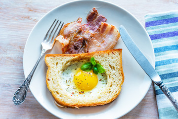 French breakfast - fried egg in toast and bacon
