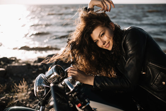 smiling beautiful woman sitting on motorcycle